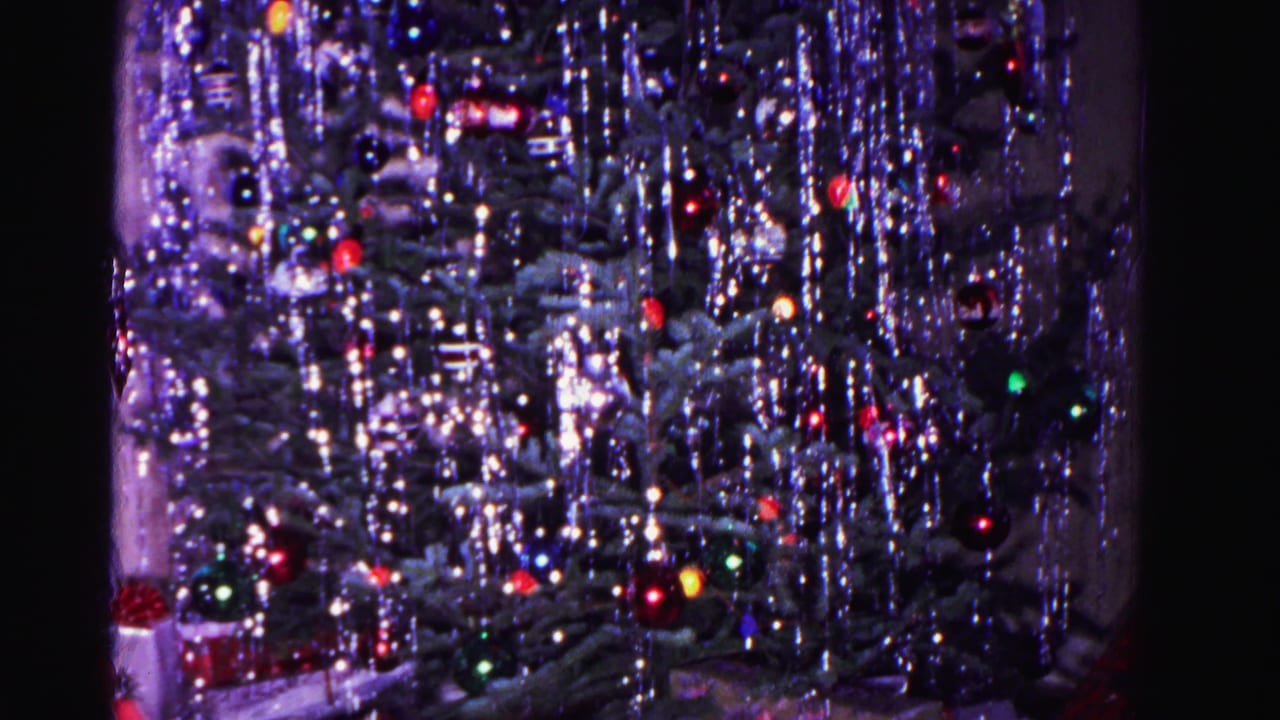 Close-up of a Christmas tree with heavy silver tinsel and multicolored glass ornaments, circa 1962, 8mm home movie.