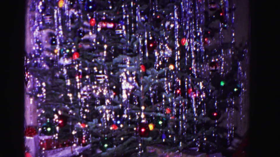 Close-up of a Christmas tree with heavy silver tinsel and multicolored glass ornaments, circa 1962, 8mm home movie.