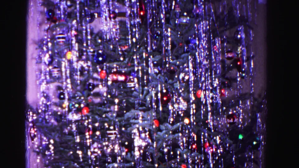 Densely tinsel-draped Christmas tree with multicolored glass ornaments, final frame of Hagerstown, Maryland home movie, circa 1962.