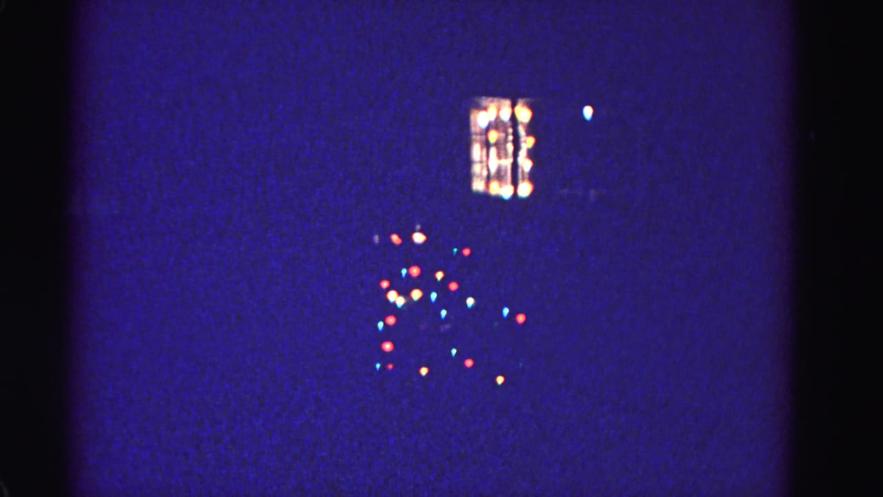 Multicolored Christmas tree lights and house window glow on a winter night, 8mm film, Hagerstown Maryland, circa 1962