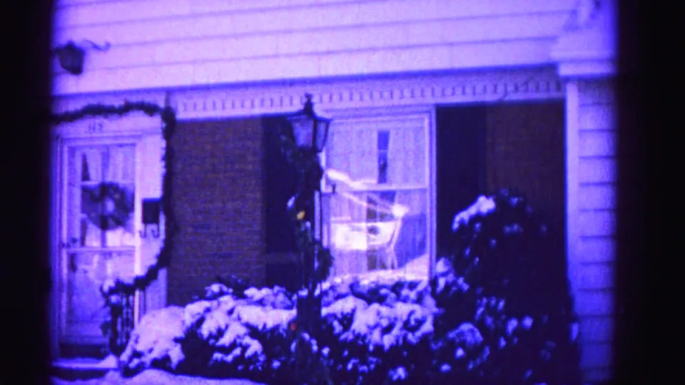 Brick suburban house with holiday wreaths, door garland, snow-covered shrubs, and a lantern post, 8mm film, Hagerstown Maryland, circa 1962