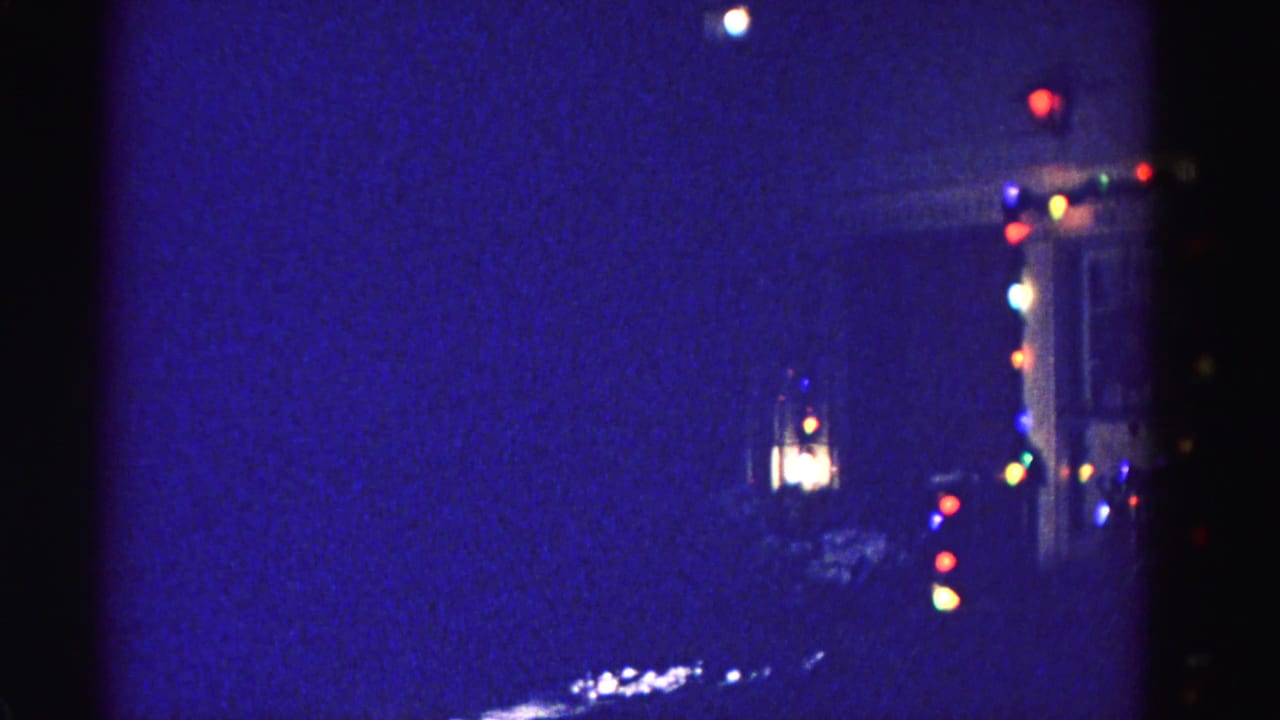 Hanging lantern and multicolored bulb lights on a residential porch corner at night, Hagerstown, Maryland area, circa 1962.