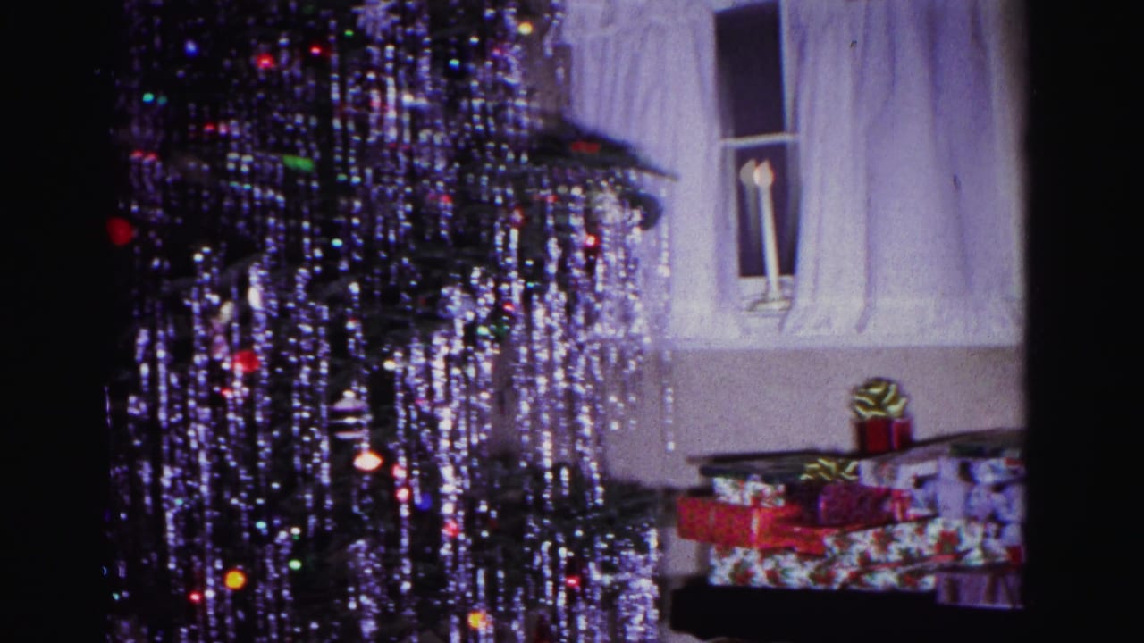 Heavily tinsel-draped Christmas tree in a domestic interior consistent with early-1960s American home decoration; wrapped presents beneath tree, Hagerstown Maryland.