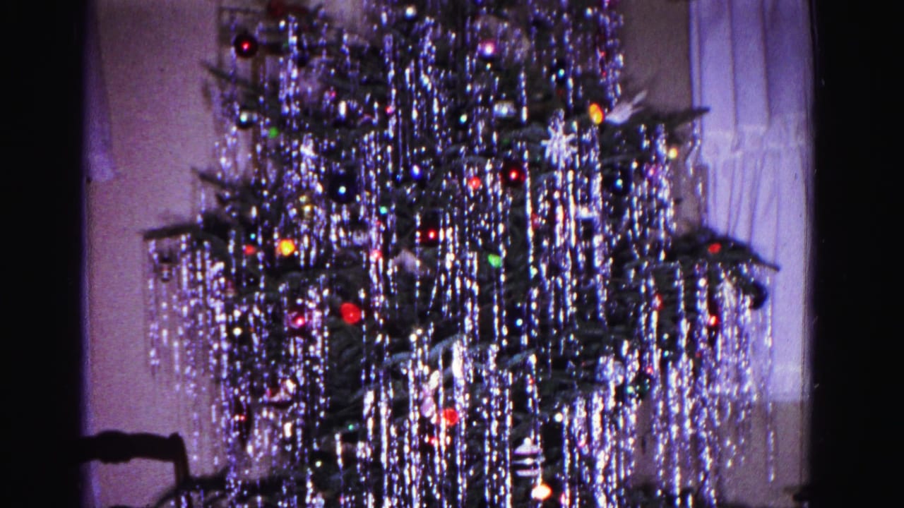 Lower portion of a tinsel-decorated Christmas tree in a 1962 domestic interior; sheer curtains and window visible in background, Hagerstown Maryland.