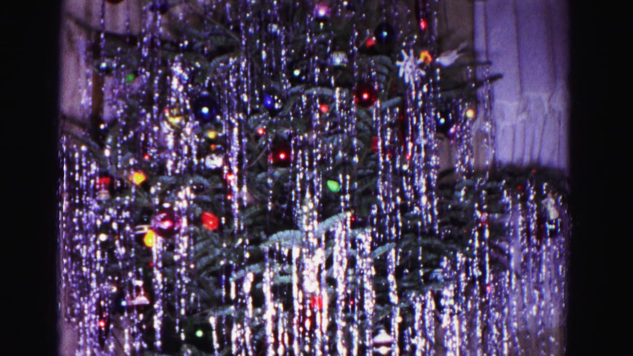 Christmas tree heavy with silver tinsel and multicolored ornaments at clip's end, from a 1962 8mm home movie in Hagerstown, Maryland.