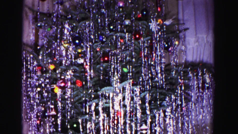 Christmas tree heavy with silver tinsel and multicolored ornaments at clip's end, from a 1962 8mm home movie in Hagerstown, Maryland.