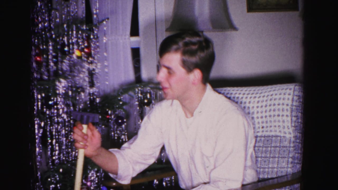 Young man decorating a silver-tinsel Christmas tree in a mid-century American living room, Hagerstown, Maryland, circa 1962.