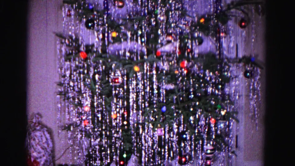 1962 8mm home movie: Christmas tree with heavy tinsel decoration and ornaments in a domestic interior, Hagerstown, Maryland.
