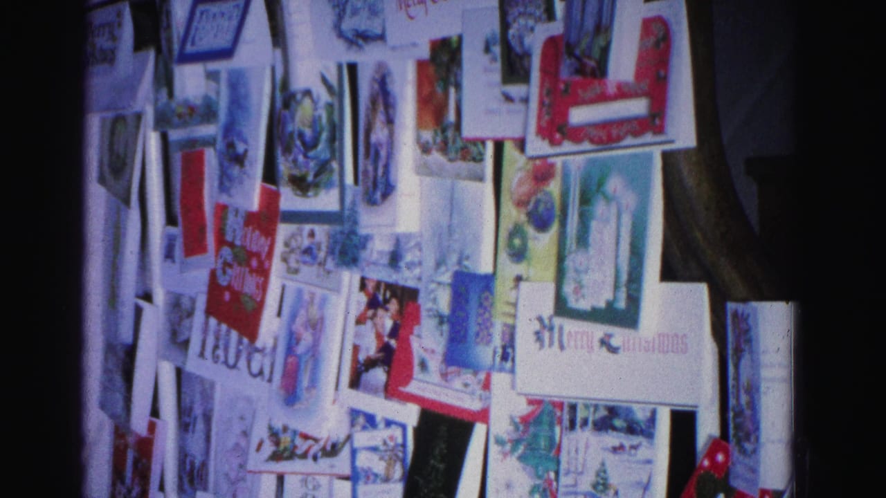 Overlapping Christmas cards pinned to a wall, 8mm home movie, Hagerstown Maryland circa 1962; 'Noel' text legible on at least one card.