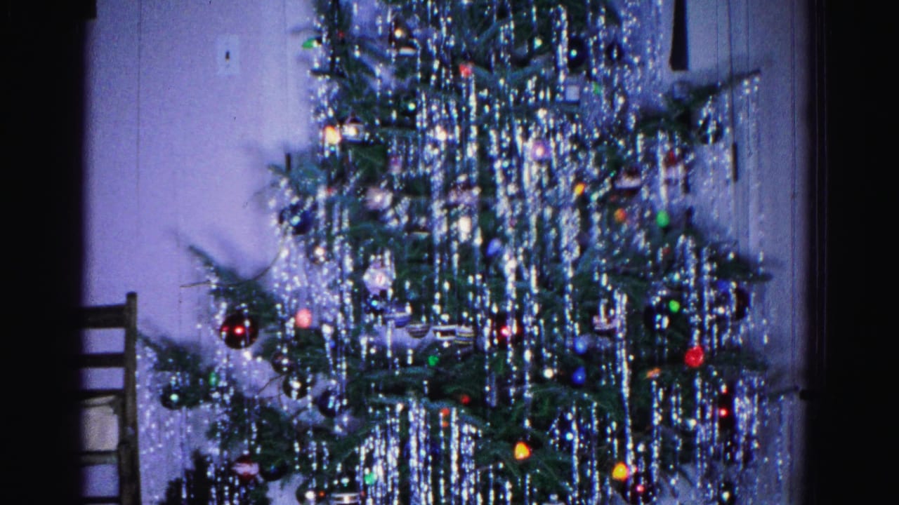 Heavily tinseled Christmas tree with colored ornaments in a home living room, Hagerstown Maryland, 1962, 8mm home movie