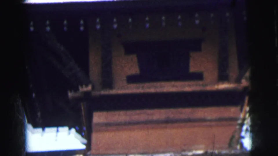 Ground-level view of lower floors of an ornate terracotta and dark timber building in Calcutta, India, circa 1962, shot on 8mm film.