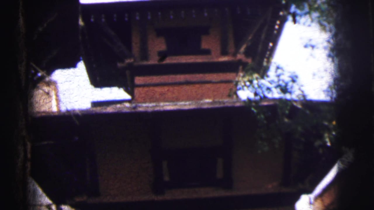 Mid-tilt view of the same multi-storey brick building, upper tier and decorative roofline visible against bright sky.