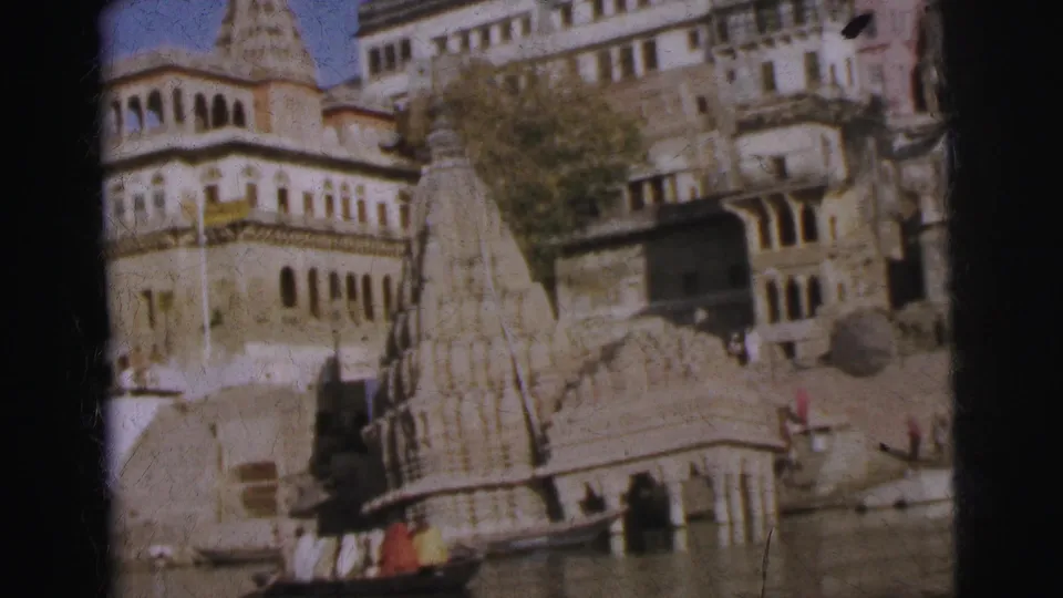 Temple shikhara spires and tiered ghat complex photographed from a boat on the river, Calcutta, circa 1962, 8mm colour.