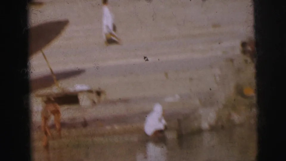 Stone ghat steps showing multiple parasols and people in white garments near the waterline, consistent with a Calcutta riverside location circa 1962.