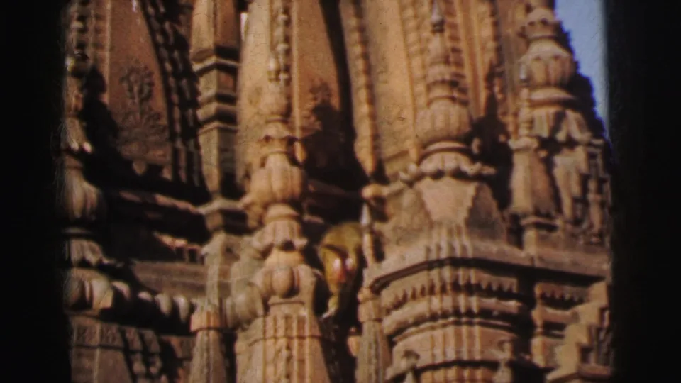 A primate among carved stone columns and figurative relief carvings on an ornate Hindu temple facade, attributed to Calcutta, India, circa 1962, 8mm film.