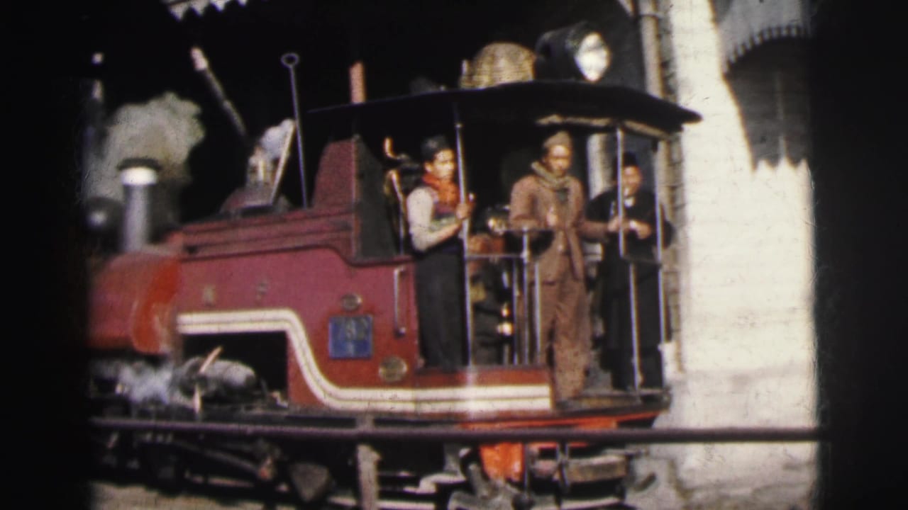Close shot of red steam locomotive cab with two crew members visible, one in a red neckerchief, consistent with 1960s Indian railway operations in Calcutta.