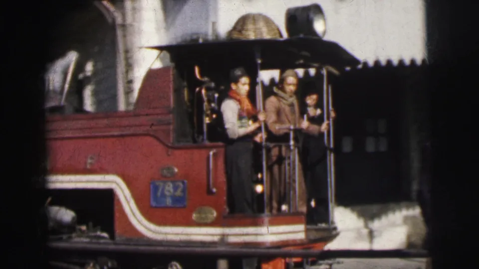 Red steam locomotive bearing number plate 782 in Calcutta circa 1962; three figures — two adults and a possible smaller person — visible on the open platform.