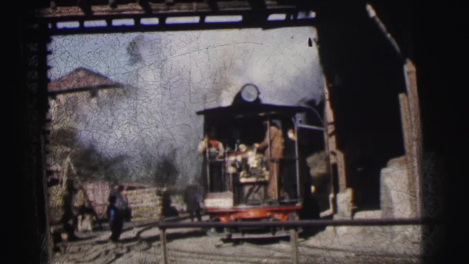 Small open-cab narrow-gauge steam locomotive in industrial yard with workers and bystanders, Calcutta India circa 1962, 8mm home movie