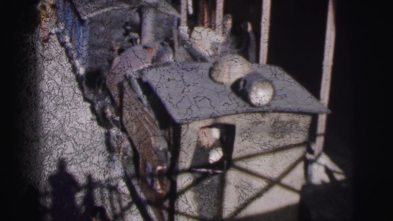 Close overhead view of a steam locomotive cab and boiler, likely at Calcutta railway station circa 1962, showing a figure near the cab on faded 8mm color film.