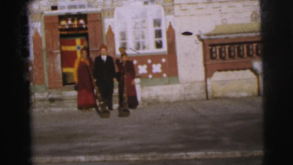 8mm color frame circa 1962 of robed figures and a suited man before a Tibetan-style decorated building exterior, Calcutta.