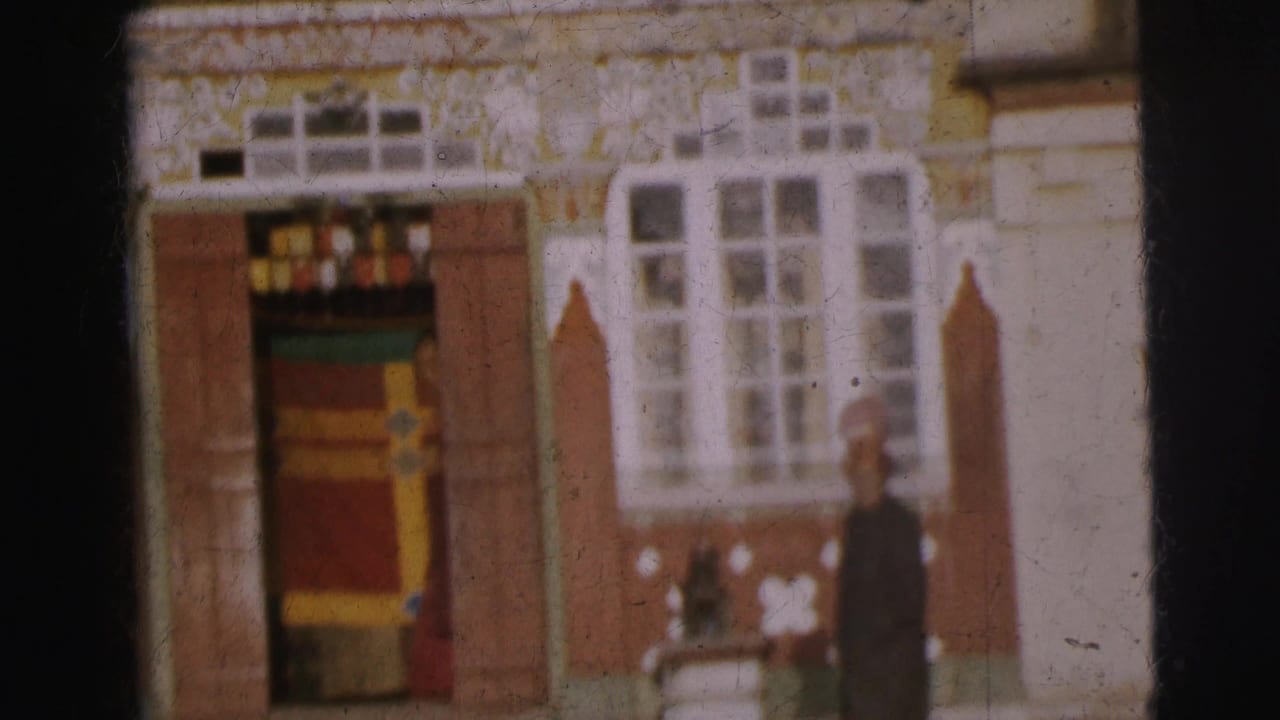 Ornate building in Calcutta, circa 1962, with decorated doorway banding and white wall motifs; a single figure, partially cropped, stands at far right.