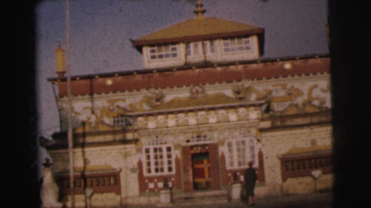 Same ornate building at a slightly different angle; figure visible to the right of center; gold reliefs on red facade prominent.