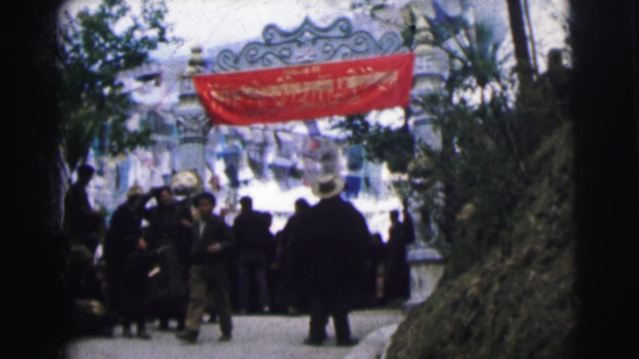 8mm color film frame of a crowd under a red banner at a decorated archway gate, Calcutta, India, circa 1962; people visible from behind.