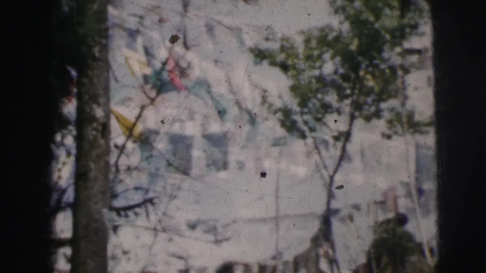 8mm color frame showing decorative pennant flags among tree branches, likely at a public gathering site, Calcutta, circa 1962.