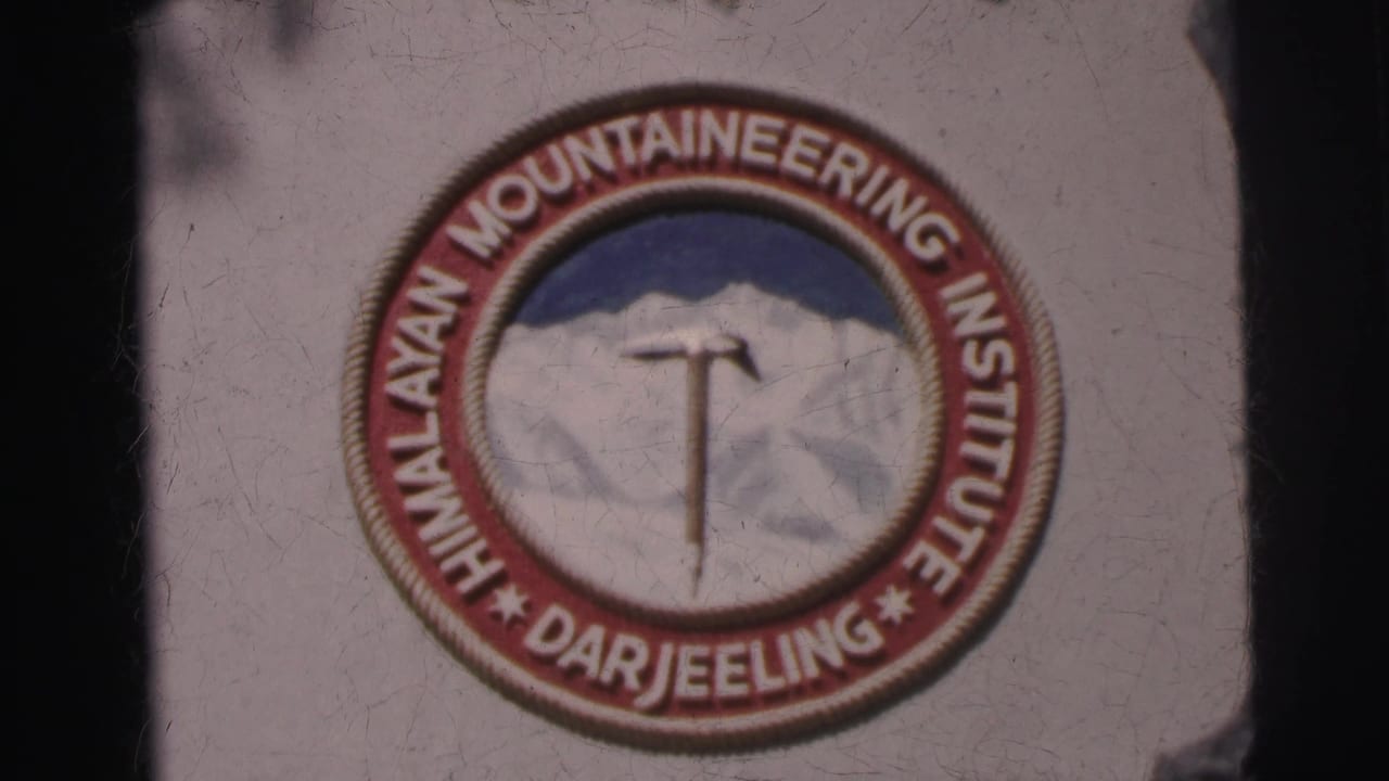 Close 8mm frame of the HMI Darjeeling logo, showing the circular text, mountain graphic, and central ice axe.