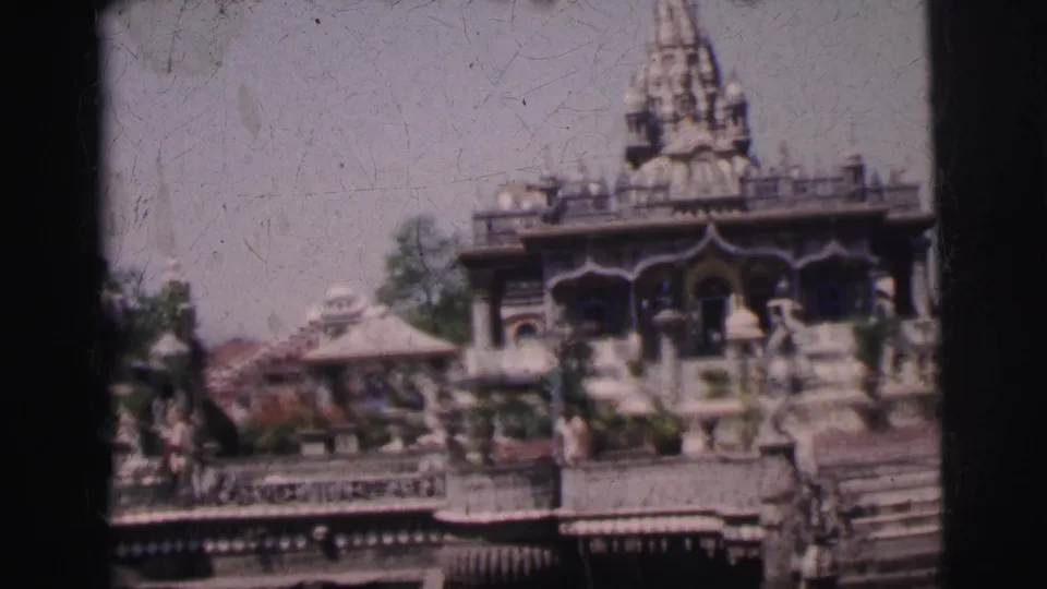 Continued 8mm frame circa 1962 of the Calcutta temple complex, showing the carved spire, ornate stone pavilions, and decorative balustrades under natural daylight.