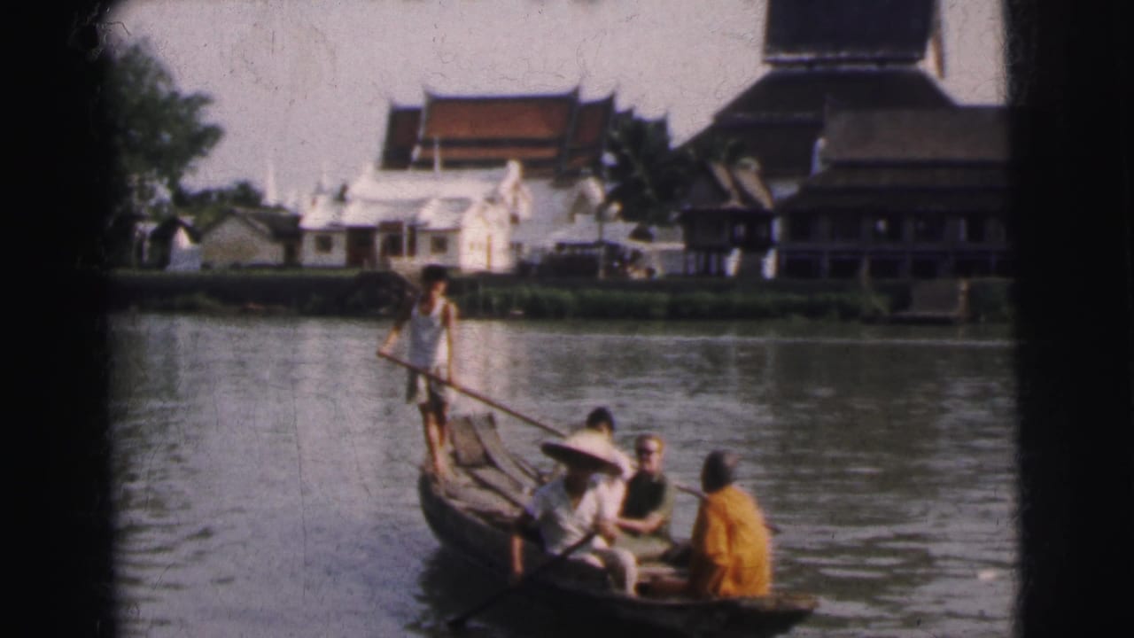 1962 Calcutta frame of a gondola-style wooden boat on the river, with passengers seated and a man paddling from the stern.