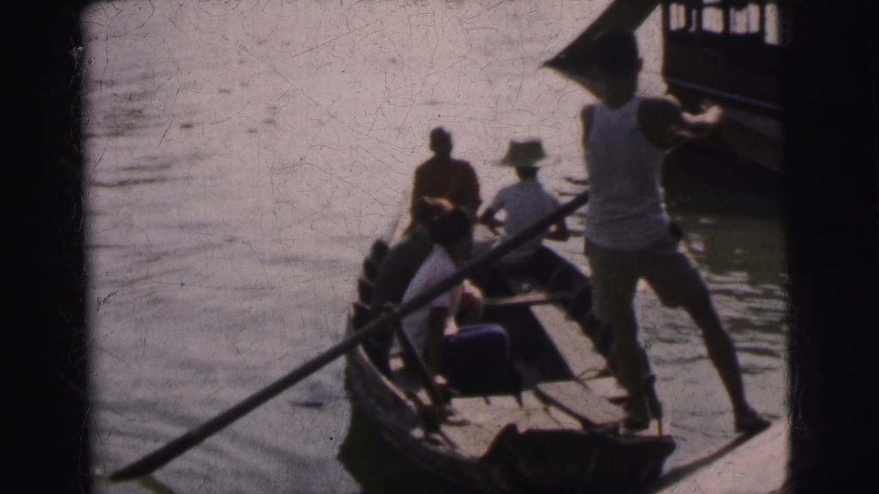 1962 Calcutta river scene with seated travelers in a narrow wooden boat and a standing boatman using a pole.
