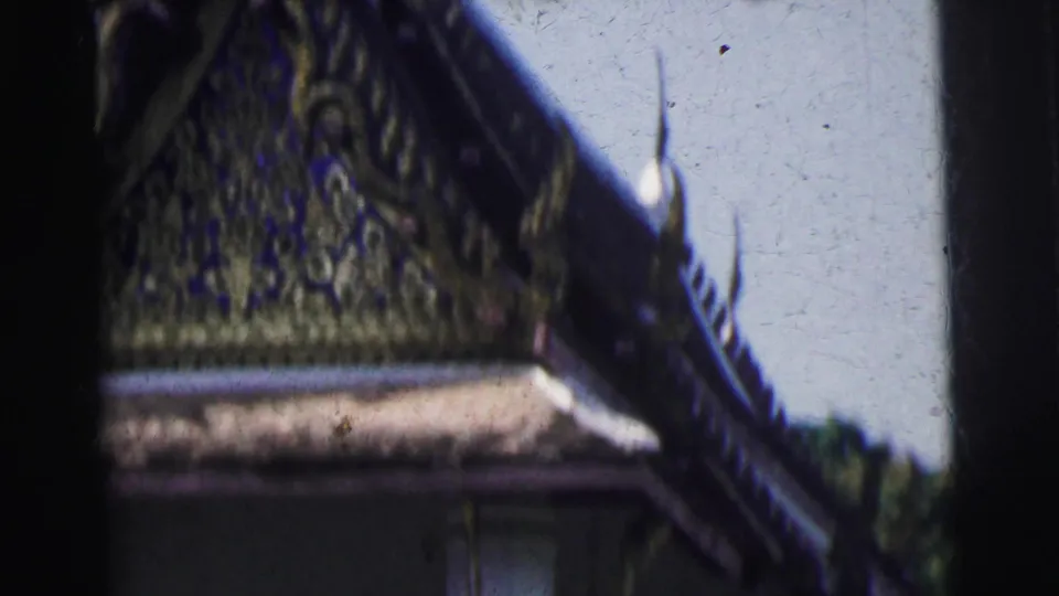 Close 1962 Calcutta home-movie view of temple roof ornament, gilded carvings, and a pointed roof element against bright sky.