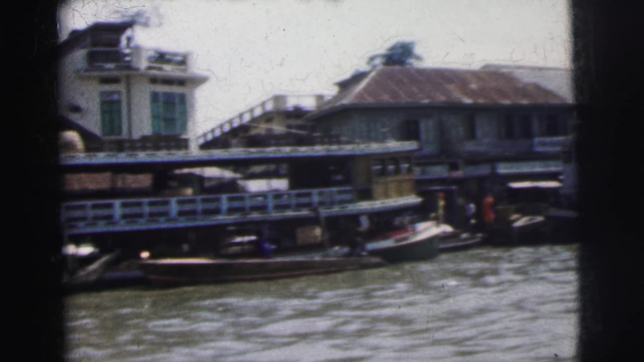 Loaded river boat and waterfront buildings seen from a moving camera.