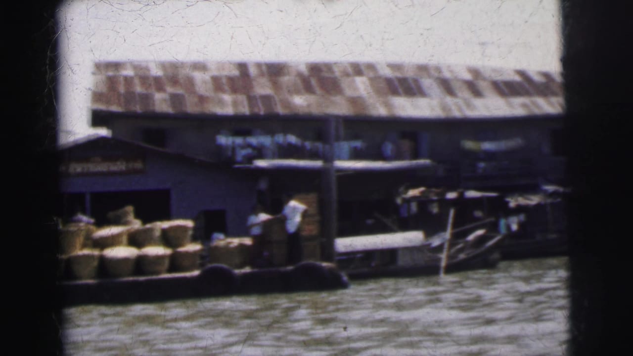 Small boats and dock structures beside a riverside market building.