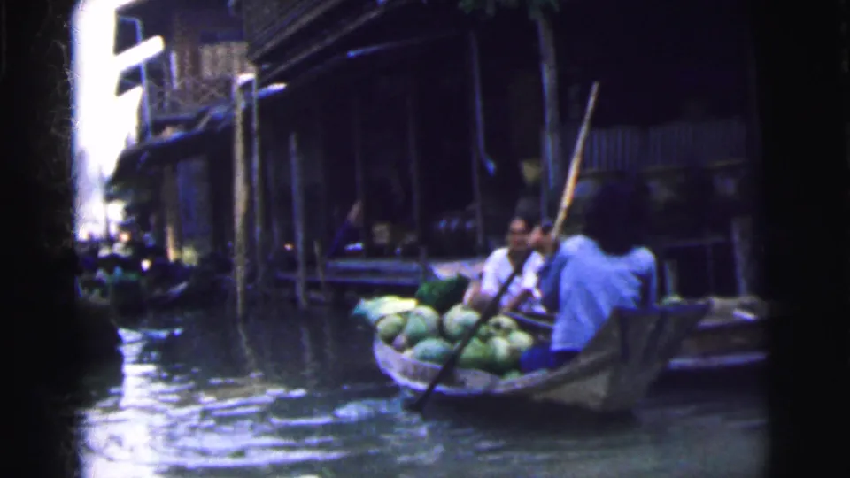Vendors or passengers sit in a wooden boat loaded with produce along the Calcutta waterway market.