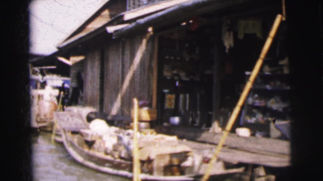 Boat pulled alongside a waterside shop with poles and goods visible.