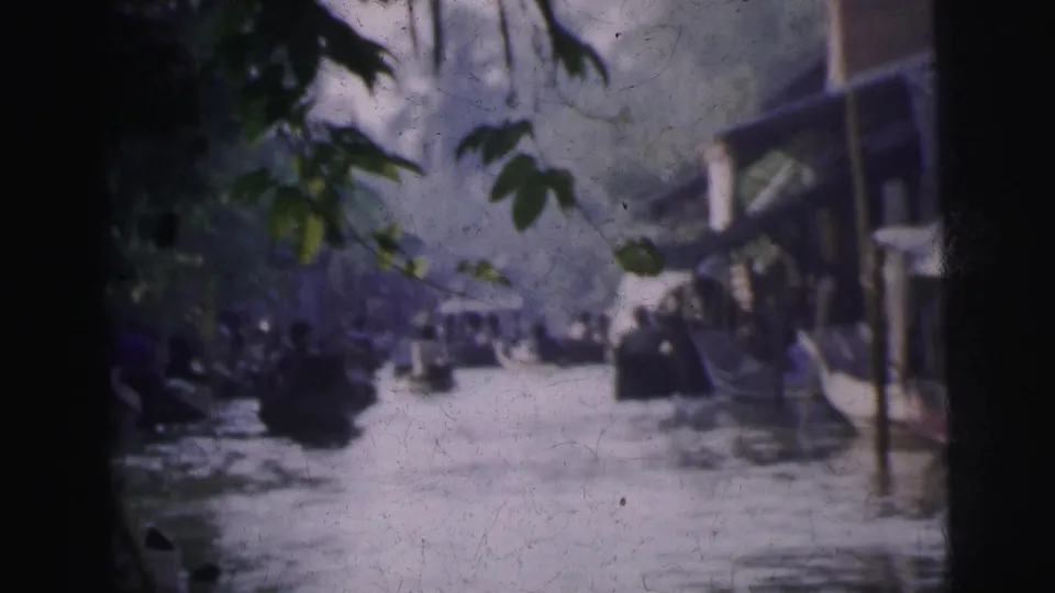 Calcutta waterway scene from 1962 with small boats, overhanging trees, buildings, and distant pedestrians.