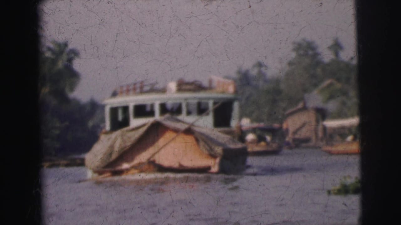 Houseboat-like vessel and riverside buildings seen across the water.