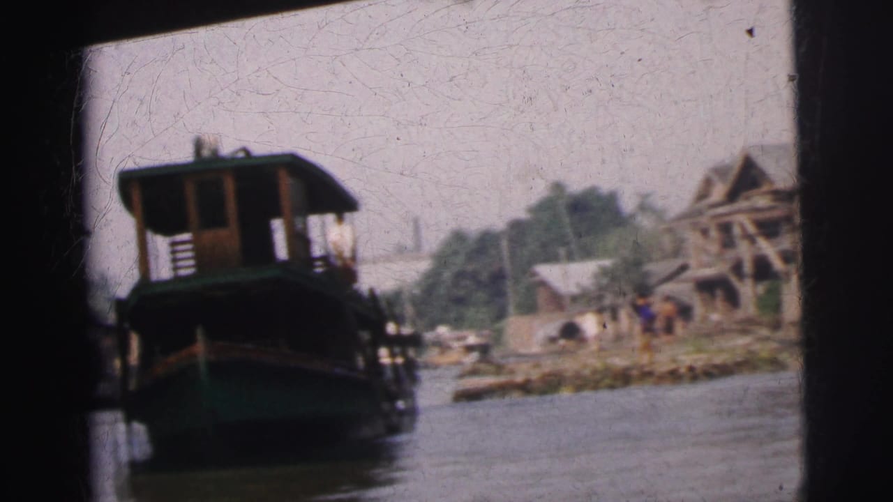 1962 Calcutta river view from a moving boat, with a green ferryboat and wooden riverside structures in the background.