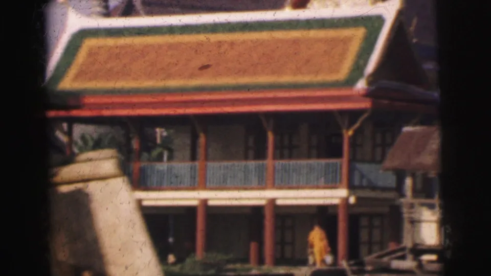 1962 Calcutta travel frame showing a temple-like building, a saffron-robed monk below, and nearby riverside structures.