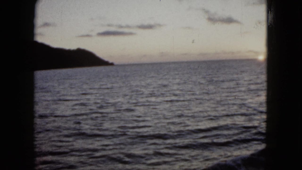 1962 Acapulco 8mm frame with open water, a silhouetted shoreline, and fading sky near sunset.