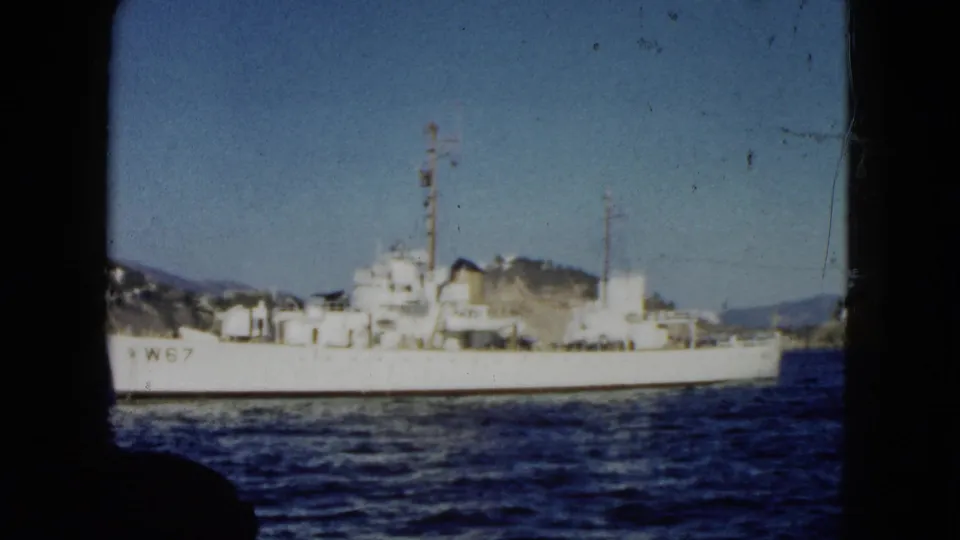 1962 Acapulco 8mm view of the white W67-marked vessel passing across the frame with hills beyond.