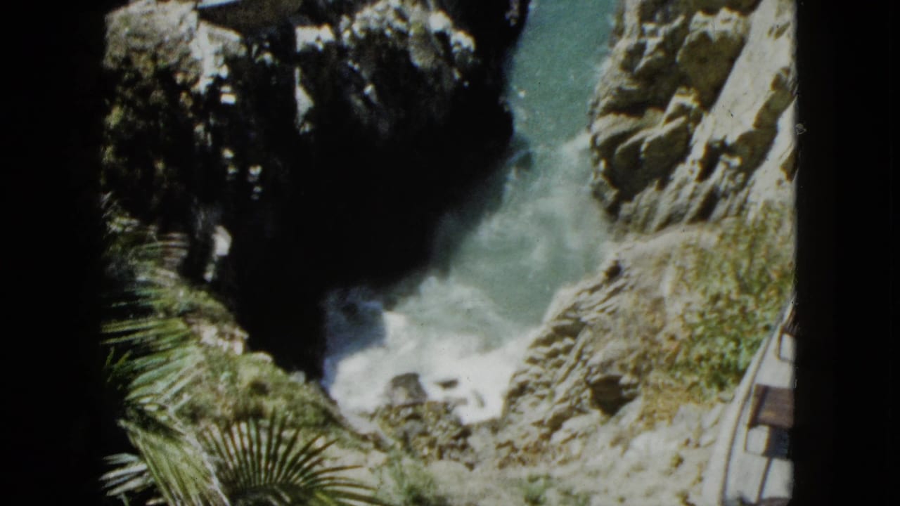 Continuation of the overlook perspective showing wave surge in a narrow rocky coastal passage, Acapulco, Mexico, circa 1962, on 8mm film.