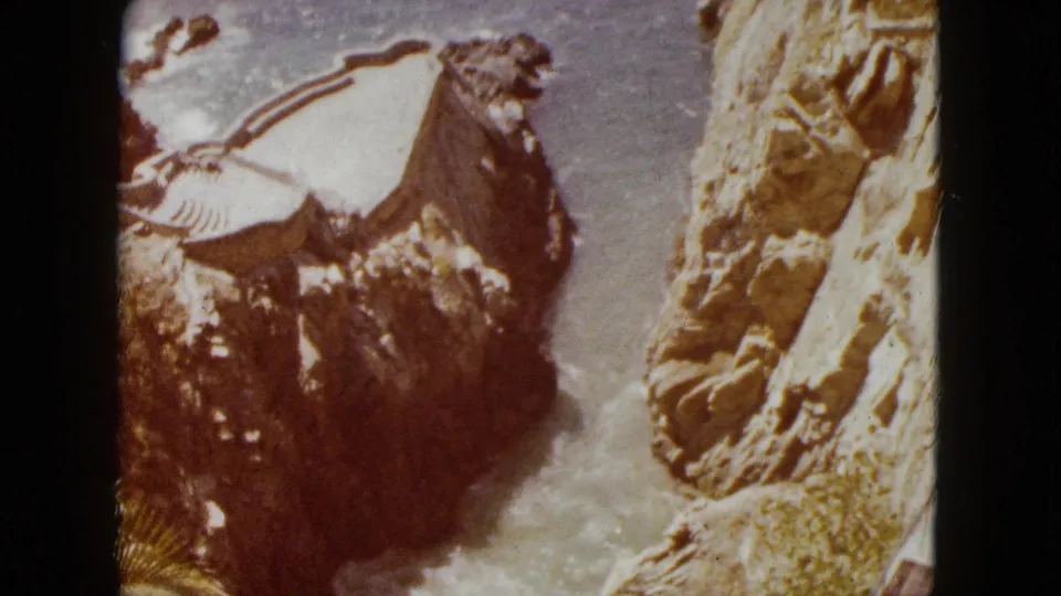 Close shot of a dramatic rock formation rising above churning surf, likely along the Acapulco coastline, circa 1962; 8mm dye shift toward brown is evident.