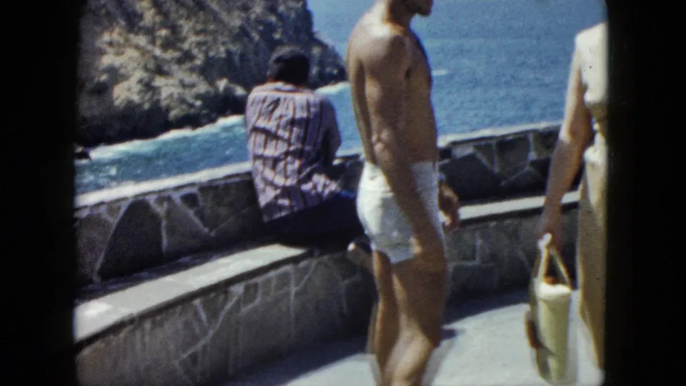 Couple and a third visitor on a stone coastal terrace above the Pacific at Acapulco, circa 1962, 8mm home movie.