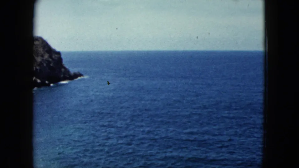 8mm travel film frame circa 1962 showing a rocky coastal headland emerging from the Pacific, possibly near Acapulco, Mexico.