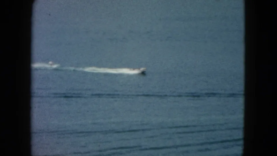 1962 Acapulco home-movie view of a small motorboat traveling across blue ocean water near the top of the frame.