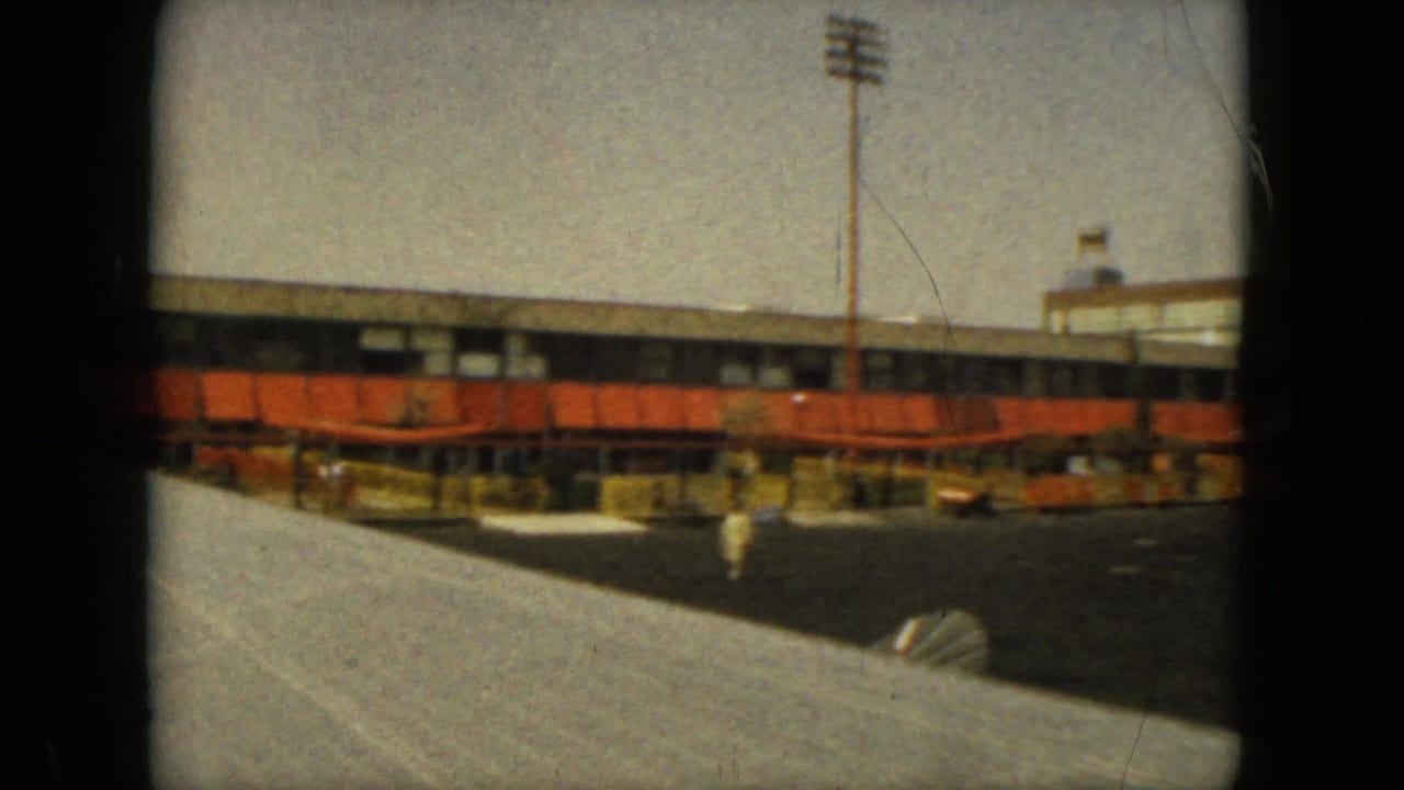 1962 Acapulco airport terminal viewed from an aircraft area, with orange awnings, ramp lighting, tarmac, and a wing edge visible.