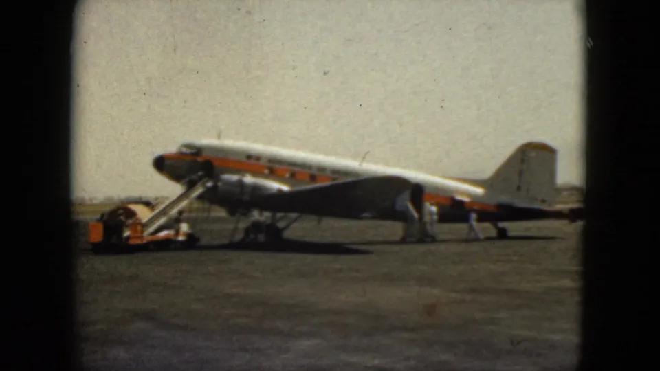1962 Acapulco airport scene with a propeller airliner, mobile stairs, and crew activity on the apron.